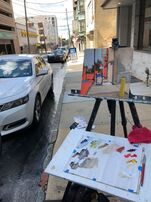 Sarah Baptist, urban landscape oil painter, painting on location in Wilmington Delaware. A street scene with sidewalk, buildings on the side and a parked car. sarah likes catching the sense of walking down the city street.